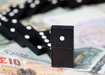 Image showing Fallen dominoes on bank notes