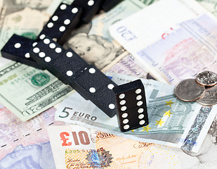 Image showing Fallen dominoes on bank notes