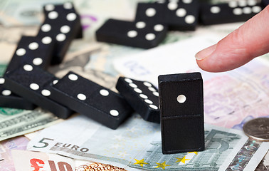 Image showing Standing dominoes on bank notes