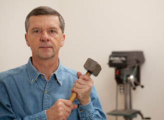 Image showing Senior man holding a large hammer