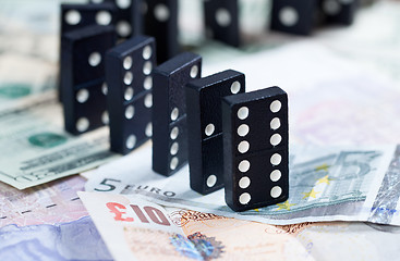 Image showing Standing dominoes on bank notes