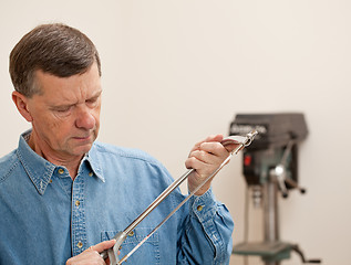 Image showing Senior man holding a metal saw 