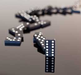 Image showing Dominoes collapsed on reflective surface