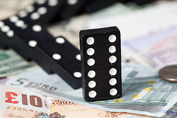 Image showing Fallen dominoes on bank notes