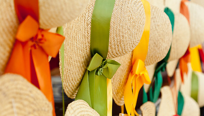 Image showing Row of straw hats with ribbons