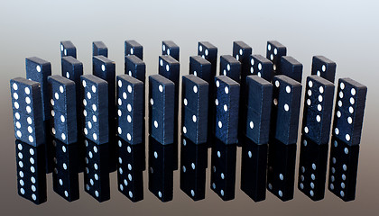 Image showing Dominoes standing on reflective surface