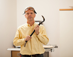 Image showing Senior man holding a crowbar