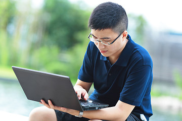 Image showing Young man using laptop outdoor