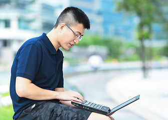 Image showing Young man using laptop outdoor