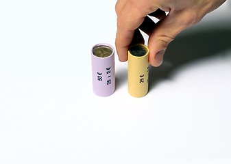 Image showing Hand grabbing a Euro coin roll