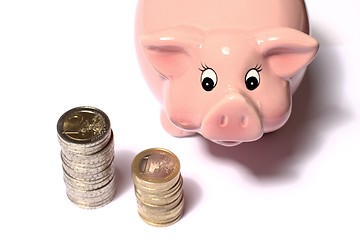 Image showing Piggy bank watching coinstacks