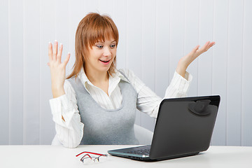 Image showing Delighted girl looks at a monitor