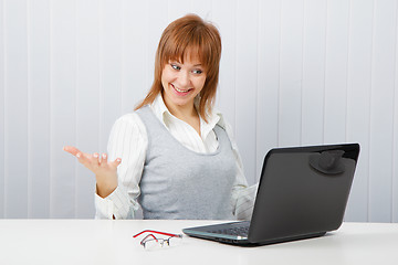 Image showing Delighted girl looks at a monitor