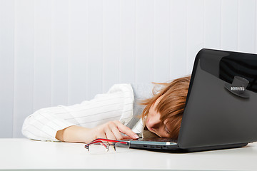 Image showing Tired girl lies on a table