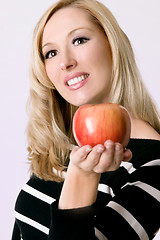 Image showing Female holding a fresh red apple
