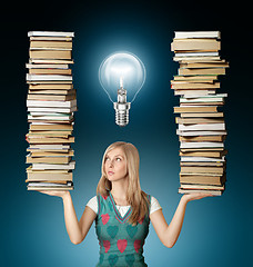 Image showing woman with many books in her hands and bulb