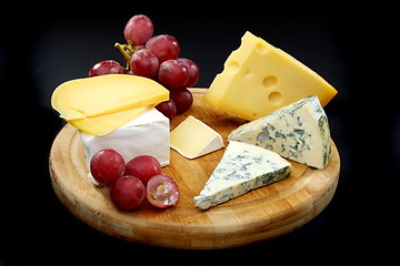 Image showing Cheese and grapes on a wooden board.