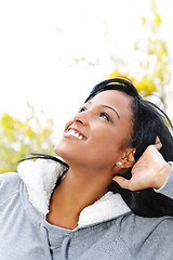 Image showing Smiling young woman outdoors looking up