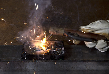 Image showing welding on open hard disk drive in dark rusty background