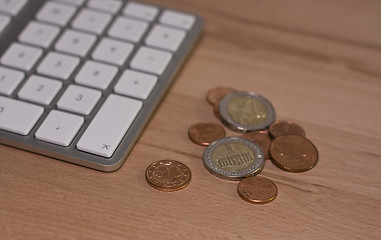 Image showing Keyboard and euro coins on wooden desk