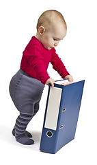 Image showing small child standing next to blue ring binder