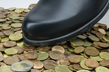 Image showing black shoe walking on money