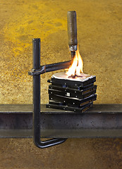 Image showing burning hard drives compressed with clamp