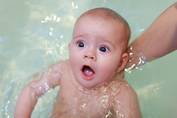 Image showing Small baby bathing