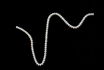 Image showing White pearls on the black silk 