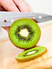 Image showing Woman's hands cutting kiwi