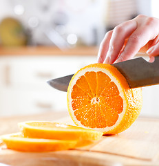 Image showing Woman's hands cutting orange