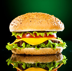 Image showing Tasty and appetizing hamburger on a darkly green