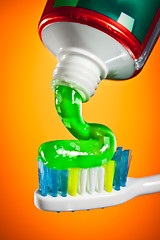 Image showing toothpaste being squeezed onto a toothbrush