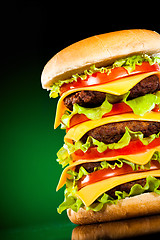 Image showing Tasty and appetizing hamburger on a darkly green