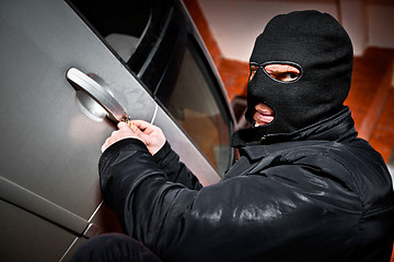 Image showing robber and the thief in a mask hijacks the car