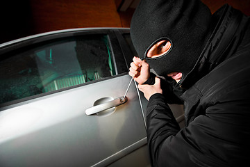 Image showing robber and the thief in a mask hijacks the car