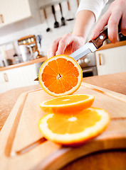 Image showing Woman's hands cutting orange