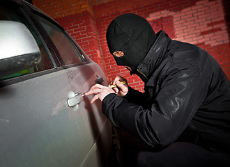 Image showing robber and the thief in a mask hijacks the car