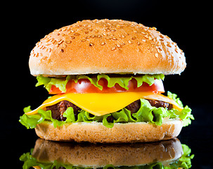 Image showing Tasty and appetizing hamburger on a dark