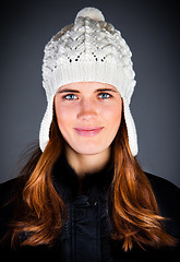 Image showing Portrait of the young girl in a winter cap on the dark