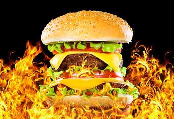 Image showing Tasty hamburger on fire on a dark