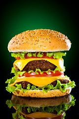 Image showing Tasty and appetizing hamburger on a darkly green