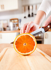 Image showing Woman's hands cutting orange