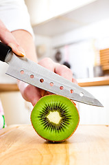 Image showing Woman's hands cutting kiwi