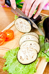 Image showing Woman's hands cutting aubergine eggplant