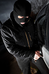 Image showing robber and the thief in a mask hijacks the car