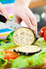 Image showing Woman's hands cutting aubergine eggplant