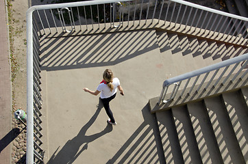 Image showing Girl setting downstairs railings sunlight shadows