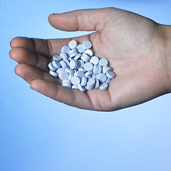 Image showing hand holding blue pills