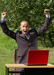 Image showing man with red laptop working outdoors